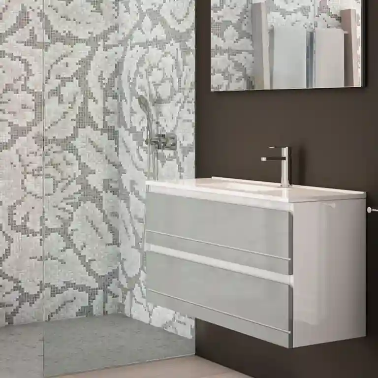 Movel suspenso de casa de banho Hilton 1 Movel suspenso de casa de banho Hilton com duas gavetas largas e lavatório cerâmico embutido no tampo, instalado numa parede escura.