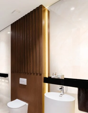 Ambiente com Pavimento cerâmico 60x120 Florência Marfil – casa de banho moderna com madeira vertical e louça suspensa