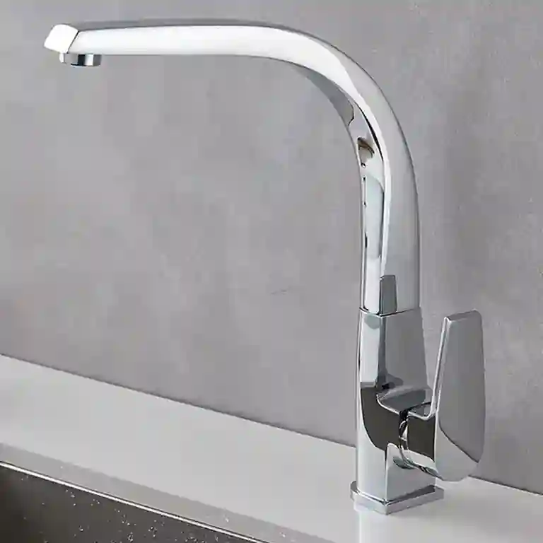 Torneira de cozinha moderna Madrid com bica curva e acabamento cromado espelhado, instalada numa bancada branca com lava-loiça em inox e fundo cinza claro.