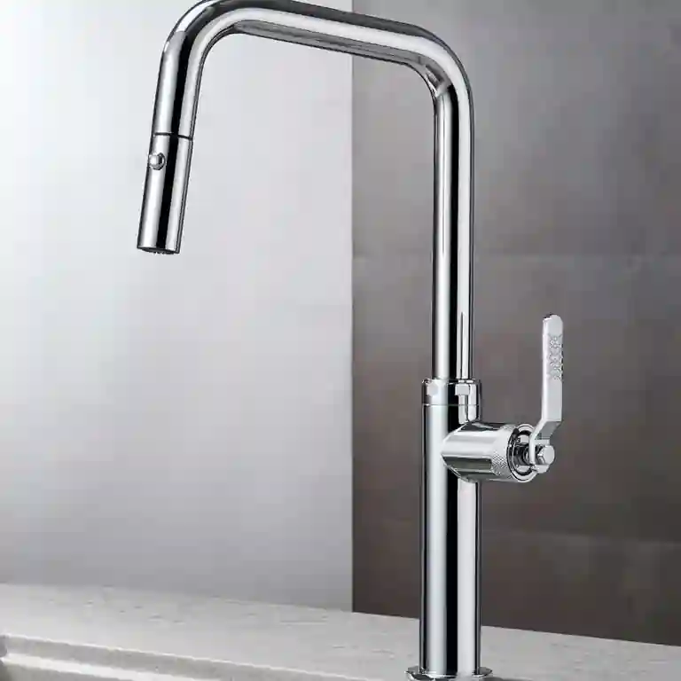 Torneira de cozinha Niza com chuveiro extraível e acabamento cromado brilhante, com manípulo lateral texturizado e bica alta em formato angular, instalada sobre bancada clara com lava-loiça duplo.