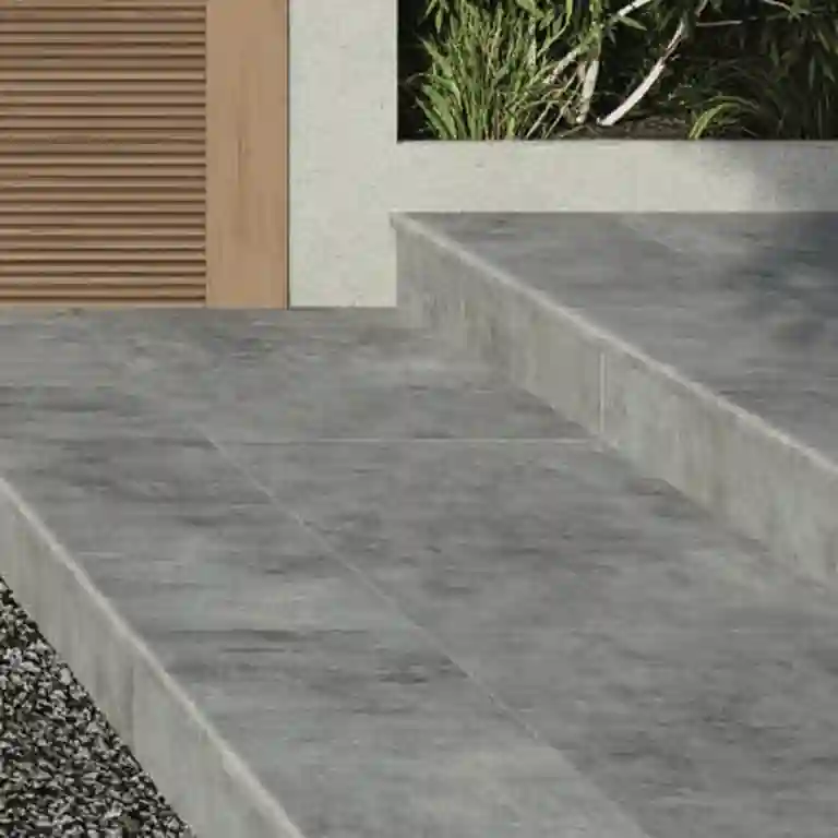 Degrau cerâmico Concrete 33x120 com acabamento boleado e efeito cimento aplicado em escada exterior moderna
