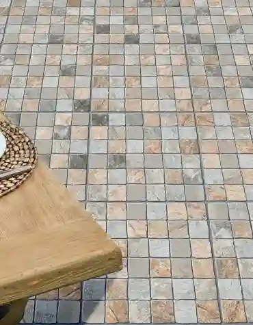 Pavimento exterior quadrado Troia com padrão tipo mosaico e tons variados, aplicado em terraço com decoração natural