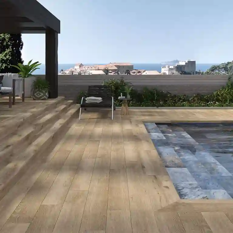 Degrau cerâmico Albar 33x120 com efeito madeira e acabamento boleado, aplicado em escadas exteriores junto à piscina