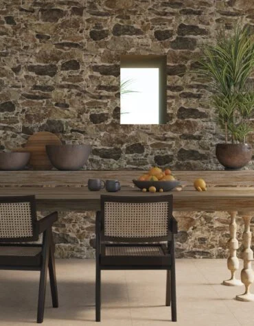 Parede com revestimento pedra rústica Muralla em estilo pedra rústica, junto a escadas suspensas em ambiente moderno.