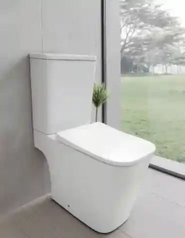 Sanita compacta quadrada Tilia instalada numa casa de banho moderna com luz natural e vista para o jardim.