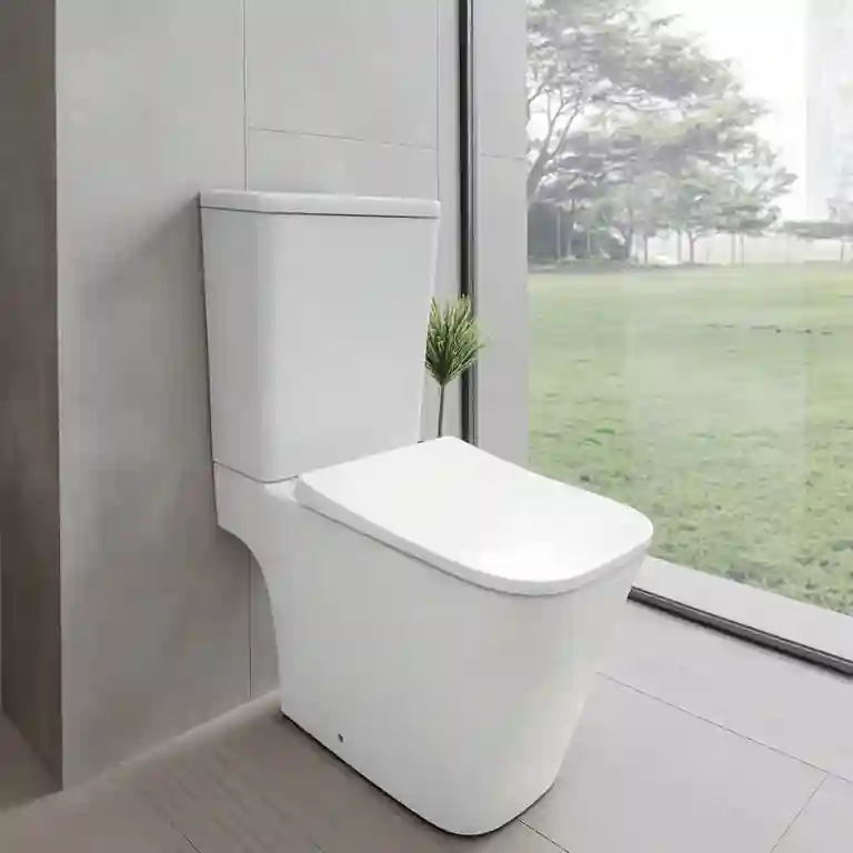 Sanita compacta quadrada Tilia instalada numa casa de banho moderna com luz natural e vista para o jardim.